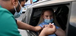 A member of the public receives a Covid-19 vaccine at a drive-through NHS (National Health Service) vaccination centre outside Ewood Park, Blackburn Rovers Football Club in Blackburn in north-west England on January 17, 2022, as the Omicron coronavirus variant spreads in the country. (Photo by Paul ELLIS / AFP)