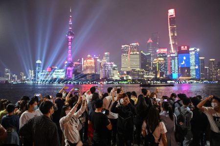 TOPSHOT - People wearing face masks visit the promenade on the Bund along the Huangpu River during a holiday on May Day, or International Workers' Day, in Shanghai on May 1, 2020. - With optimism and a heavy dose of caution, millions of Chinese hit the road or visited newly re-opened tourist sites on May 1 for an extended national holiday in a post-coronavirus confidence test. (Photo by Hector RETAMAL / AFP) (Photo by HECTOR RETAMAL/AFP via Getty Images)