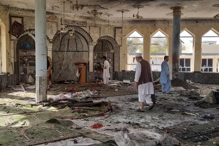 People inspect the inside of a mosque following a bombing in Kunduz province northern Afghanistan, Friday, Oct. 8, 2021. A powerful explosion in the mosque frequented by a Muslim religious minority in northern Afghanistan on Friday has left several casualties, witnesses and the Taliban's spokesman said. (AP Photo/Abdullah Sahil)