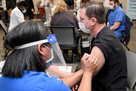 LAS VEGAS, NEVADA - DECEMBER 16:  Dr. David Obert receives a Pfizer-BioNTech COVID-19 vaccination at University Medical Center of Southern Nevada on December 16, 2020, in Las Vegas, Nevada. UMCSN received its first allotment of the vaccine on Monday and began vaccinating its front-line workers treating patients with COVID-19, including staff from the hospital’s intensive care units and emergency department. The state has averaged 20 deaths from COVID-19 per day over the past two weeks.  (Photo by Ethan Miller/Getty Images)