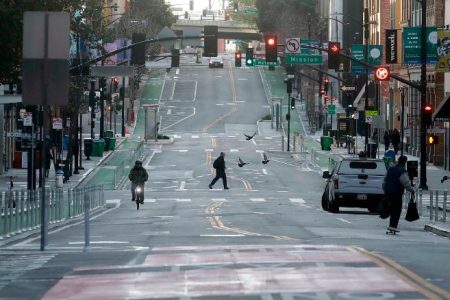 A man crosses a nearly empty street in San Francisco, Tuesday, March 17, 2020. Officials in seven San Francisco Bay Area counties have issued a shelter-in-place mandate affecting about 7 million people, including the city of San Francisco itself. The order says residents must stay inside and venture out only for necessities for three weeks starting Tuesday. (AP Photo/Jeff Chiu)