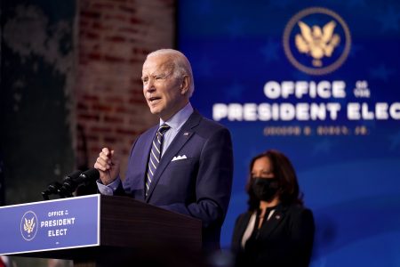 President-elect Joe Biden speaks at The Queen theater, Monday, Dec. 28, 2020, in Wilmington, Del. Vice President-elect Kamala Harris listens at right. (AP Photo/Andrew Harnik)
