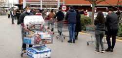FILE PHOTO: A masked customer leaves with shopping as other customers queue to enter a Costco Wholesalers in Chingford, Britain March 15, 2020. REUTERS/John Sibley