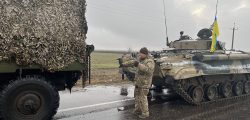 Ukrainian soldiers pose with captured military vehicles of Russian forces in the Nikolaev, a city near the Black Sea in southern Ukraine, on Wednesday March 2, 2022.