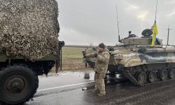 Ukrainian soldiers pose with captured military vehicles of Russian forces in the Nikolaev, a city near the Black Sea in southern Ukraine, on Wednesday March 2, 2022.