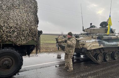 Ukrainian soldiers pose with captured military vehicles of Russian forces in the Nikolaev, a city near the Black Sea in southern Ukraine, on Wednesday March 2, 2022.