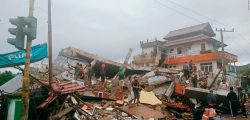Residents inspect an earthquake-damaged buildings in Mamuju, West Sulawesi, Indonesia, Friday, Jan. 15, 2021. A strong inland and shallow earthquake hit eastern Indonesia early Friday causing people to panic in parts of the country???s Sulawesi island and run to higher ground. (AP Photo/Rudy Akdyaksyah)