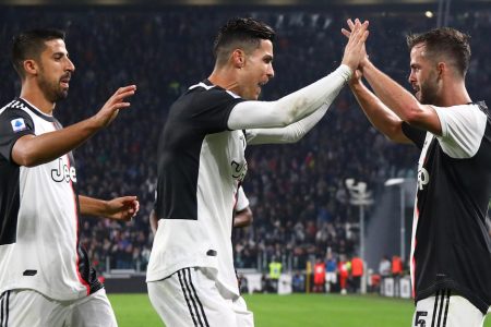 TURIN, ITALY - OCTOBER 19: Miralem Pjanic (R) of Juventus celebrates his goal with his team-mates Sami Khedira (L) and Cristiano Ronaldo (C) during the Serie A match between Juventus and Bologna FC at Allianz Stadium on October 19, 2019 in Turin, Italy. (Photo by Marco Luzzani/Getty Images)