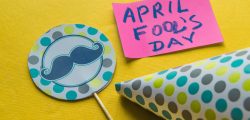 Cap, topper with a mustache and notes with the phrase April fool's day on a yellow background.