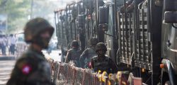 FILE PHOTO: Soldiers stand next to military vehicles as people gather to protest against the military coup, in Yangon, Myanmar, February 15, 2021. REUTERS/Stringer/File Photo