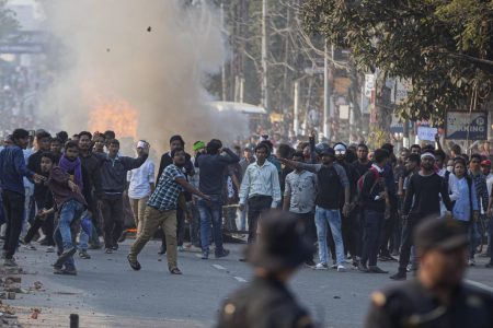 Protesters throw stones at security officers during a protest against the Citizenship Amendment Bill in Gauhati, India, on Wednesday.