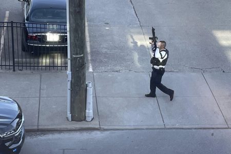 This photo provided by Reid Cornell shows police presence near the scene of a shooting in Louisville, Ky., Monday, April 10, 2023. (Reid Cornell via AP)