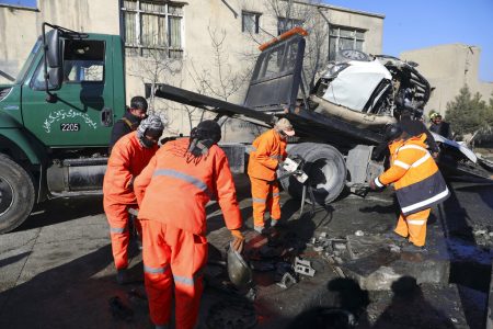 Afghan security personnel and municipality workers remove a damaged vehicle after a roadside bomb attack in Kabul, Afghanistan, Tuesday, Dec. 22, 2020. A roadside bomb tore through a vehicle in the Afghan capital of Kabul Tuesday, killing multiple people, police said. (AP Photo/Rahmat Gul)