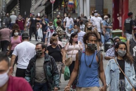 People walk through a downtown shopping district in Sao Paulo, Brazil, Wednesday, June 10, 2020. Retail shops reopened on Wednesday in Brazil's biggest city after a two-month coronavirus pandemic shutdown that aimed to contain the spread of the new coronavirus. (AP Photo/Andre Penner)