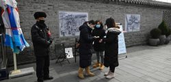 A woman uses a thermometer to check a woman?s temperature at the entrance of a business street being closed due to coronavirus epidemic in Beijing on February 21, 2020. - The death toll in China from the coronavirus epidemic rose to 2,233 on February 21 after 115 more people died in Hubei province, the hard-hit epicentre of the outbreak. (Photo by STR / AFP)