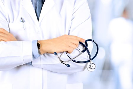 Portrait an unknown male doctor holding a stethoscope behind