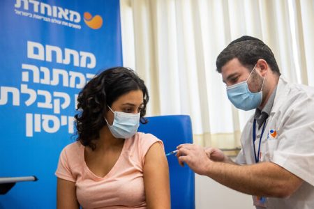 An Israeli teacher receives a dose of the COVID-19 vaccine, at Meuhedet Covid-19 vaccination center in Jerusalem, on August 24, 2021. Photo by Yonatan Sindel/Flash90 *** Local Caption ***  ðâã ðâéó
ä÷åøåðä
àøðä
÷åøåðä
çéñåï
îàåçãú
àæøçéí
çéñåðéí
