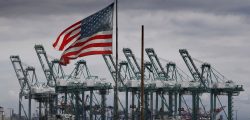 TOPSHOT - The US flag flies over shipping cranes and containers after a report said the United States and China are close to reaching a major trade deal that would see both sides lower some of the tariffs imposed during an often-bitter trade war, in Long Beach, California on March 4, 2019. (Photo by Mark RALSTON / AFP) (Photo by MARK RALSTON/AFP via Getty Images)