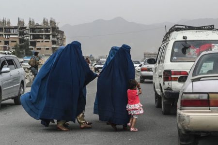 Women wearing a burqa cross a road as they walk towards a local taxi in Kabul on July 31, 2021. (Photo by SAJJAD HUSSAIN / AFP) (Photo by SAJJAD HUSSAIN/AFP via Getty Images)
