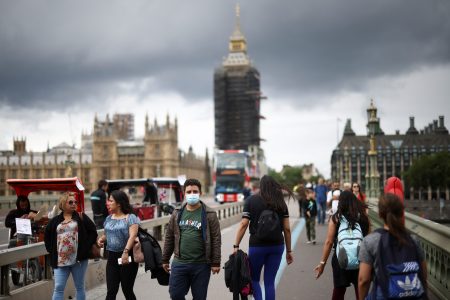 People, some wearing protective face masks, walk over Westminster Bridge, amid the coronavirus disease (COVID-19) pandemic, in London, Britain, July 4, 2021. REUTERS/Henry Nicholls