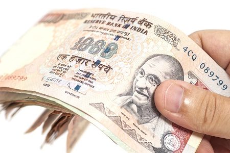 Hand with Indian thousand rupee notes