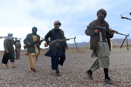 Former Taliban fighters walk with their weapons after they joined Afghanistan's government forces during a ceremony in Herat province on March 31, 2012. Thirty six fighters left the Taliban to join government forces in western Afghanistan. The Taliban, ousted from power by a US-led invasion in the wake of the 9/11 attacks, announced earlier this month that they planned to set up a political office in Qatar ahead of talks with Washington. AFP PHOTO / Aref KARIMI (Photo by Aref Karimi / AFP)