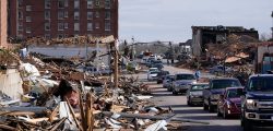 People survey damage from a tornado is seen in Mayfield, Ky., on Saturday, Dec. 11, 2021. Tornadoes and severe weather caused catastrophic damage across multiple states late Friday, killing several people overnight. (AP Photo/Mark Humphrey)