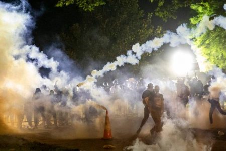 Tear gas rises above as protesters face off with police during a demonstration outside the White House over the death of George Floyd at the hands of Minneapolis Police in Washington, DC, on May 31, 2020. - Thousands of National Guard troops patrolled major US cities after five consecutive nights of protests over racism and police brutality that boiled over into arson and looting, sending shock waves through the country. The death Monday of an unarmed black man, George Floyd, at the hands of police in Minneapolis ignited this latest wave of outrage in the US over law enforcement's repeated use of lethal force against African Americans -- this one like others before captured on cellphone video. (Photo by Samuel Corum / AFP)