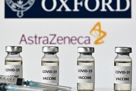 An illustration picture shows vials with Covid-19 Vaccine stickers attached and syringes, with the logo of the University of Oxford and its partner British pharmaceutical company AstraZeneca, on November 17, 2020. (Photo by JUSTIN TALLIS / AFP)