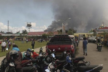 Smoke billows from burning building during protest in Wamena, Papua province, Indonesia, Monday, Sept. 23, 2019.  Hundreds of protesters in Indonesia's restive Papua province set fire to homes and other buildings Monday in a protest sparked by rumours that a teacher had insulted students. (AP Photo/George Yewun)