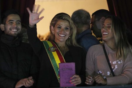 Bolivia's second Senate Vice President and opposition politician Jeanine Anez, center, wearing the Presidential sash, addresses the crowd from the balcony of the Quemado palace after she declared herself interim president of the country, in La Paz, Bolivia, Tuesday, Nov. 12, 2019. (AP Photo/Juan Karita)