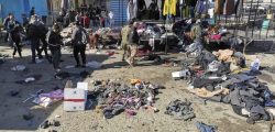 People and security forces gather at the site of a deadly bomb attack in a market selling used clothes, Iraq, Thursday, Jan. 21, 2021. Twin suicide bombings hit Iraq's capital Thursday killing and wounding civilians, police and state TV said. (AP Photo/Hadi Mizban)