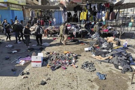 People and security forces gather at the site of a deadly bomb attack in a market selling used clothes, Iraq, Thursday, Jan. 21, 2021. Twin suicide bombings hit Iraq's capital Thursday killing and wounding civilians, police and state TV said. (AP Photo/Hadi Mizban)
