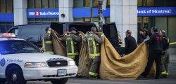 Officials carry a body into a vehicle after a van mounted a sidewalk crashing into pedestrians in Toronto on Monday, April 23, 2018. The rented van jumped onto the crowded sidewalk Monday, killing and injuring people before the driver fled and was quickly arrested in a confrontation with police, Canadian authorities said. (Aaron Vincent Elkaim/The Canadian Press via AP)