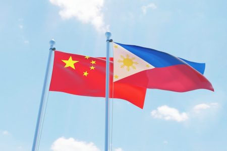 Philippines and China, two flags waving against blue sky. 3d image