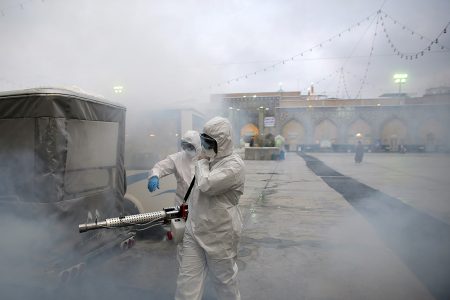 Members of the medical team spray disinfectant to sanitize outdoor place of Imam Reza's holy shrine, following the coronavirus outbreak, in Mashhad, Iran February 27, 2020. Picture taken February 27, 2020. WANA (West Asia News Agency) via REUTERS ATTENTION EDITORS - THIS PICTURE WAS PROVIDED BY A THIRD PARTY