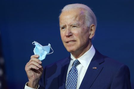 WILMINGTON, DELAWARE - NOVEMBER 09:  U.S. President-elect Joe Biden holds a protective mask as he speaks to the media after receiving a briefing from the transition COVID-19 advisory board on November 09, 2020 at the Queen Theater in Wilmington, Delaware. Mr. Biden spoke about how his administration would respond to the coronavirus pandemic. (Photo by Joe Raedle/Getty Images)