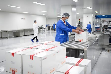 A staff member works during a media tour of a new factory built to produce a COVID-19 coronavirus vaccine at Sinovac, one of 11 Chinese companies approved to carry out clinical trials of potential coronavirus vaccines, in Beijing on September 24, 2020. (Photo by WANG ZHAO / AFP)