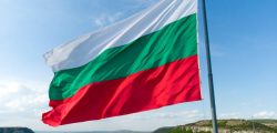 Bulgaria National Flag Waving on pole against sunny blue sky background.