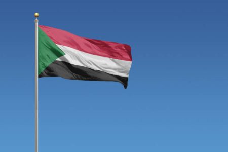 Flag of Sudan in front of a clear blue sky