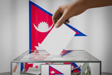 nepal-flag-hand-dropping-ballot-card-into-box-voting-election-concept_SM_Blog_Jan_2023-scaled