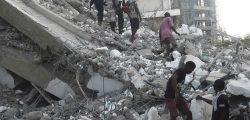 People walk to rescue workers from the rubble of a 21-storey building under construction that collapsed at Ikoyi district of Lagos, on November 1, 2021. - Several people have been trapped while unspecified number of people mostly construction workers were feared dead as a 21-storey building suddenly collapsed in the Ikoyi district of Lagos, Nigeria's commercial capital. (Photo by PIUS UTOMI EKPEI / AFP) (Photo by PIUS UTOMI EKPEI/AFP via Getty Images)