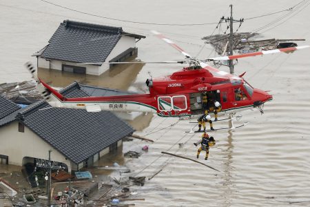 An aerial view shows a local resident being rescued from a submerged house by rescue workers using helicopter at a flooded area in Kurashiki, southern Japan, in this photo taken by Kyodo July 7, 2018. Mandatory credit Kyodo/via REUTERS ATTENTION EDITORS - THIS IMAGE WAS PROVIDED BY A THIRD PARTY. MANDATORY CREDIT. JAPAN OUT. NO COMMERCIAL OR EDITORIAL SALES IN JAPAN. - RC1B66111DD0