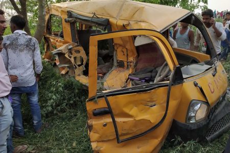 Onlookers gather around the mangled remains of a school bus after it was hit by a train in Kushinagar district in India's Uttar Pradesh state on April 26, 2018.
At least 13 children were killed and five critically injured April 26 after a train smashed into a small school bus in northern India, an official said.
 / AFP PHOTO / -