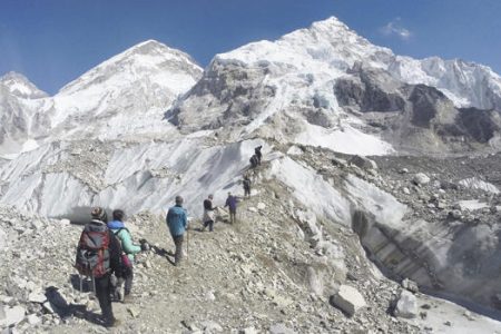 FILE - In this Monday, Feb. 22, 2016 file photo, international trekkers pass through a glacier at the Mount Everest base camp, Nepal. A Nepal official says some 30 climbers have gotten frostbite or become sick on Mount Everest, in addition to two who died in recent days on the world's highest mountain. (AP Photo/Tashi Sherpa, file)