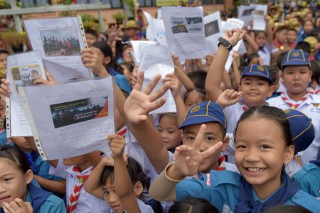 Thai students smile as they hold pictures of 12 boys and a fooball coach at a school in front of hospital where the boys rescued after being trapped in a nearby cave for 18 harrowing days have been brought for observation in Chiang Rai on July 11, 2018.
The final five members of a young football team were rescued from a flooded Thai cave on July 10, after spending 18 harrowing days trapped deep inside, completing an astonishing against-the-odds rescue mission that captivated the world. / AFP PHOTO / TANG CHHIN Sothy