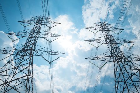 Two power tower agaist clouds and blue sky