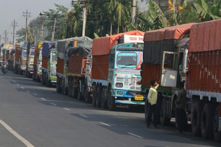 Indian truck drivers stay near their trucks parked close to the India-Nepal border at Panitanki, some 40 kms from Siliguri on December 2, 2015, during the ongoing dispute between Nepal and India. Scores of trucks have been stranded at a key border checkpoint for over two months following protests by ethnic minorities over the Himalayan nation's new constitution introduced in September. Movement across other border checkpoints has also slowed to a crawl, leading to a nationwide fuel crisis and short supplies of medicines. AFP PHOTO / Diptendu DUTTA