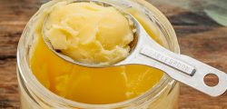 jar and measuring tablespoon of ghee - clarified butter