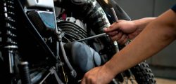 Image is Close up,People are repairing a motorcycle Use a wrench and a screwdriver to work.